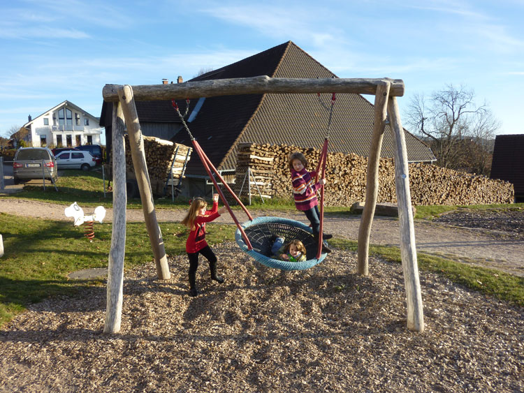 Kinder Schaukeln auf dem Spielplatz im Schwarzwald