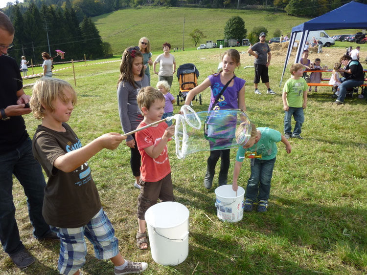 Kinder machen Seifenblasen und es klappt